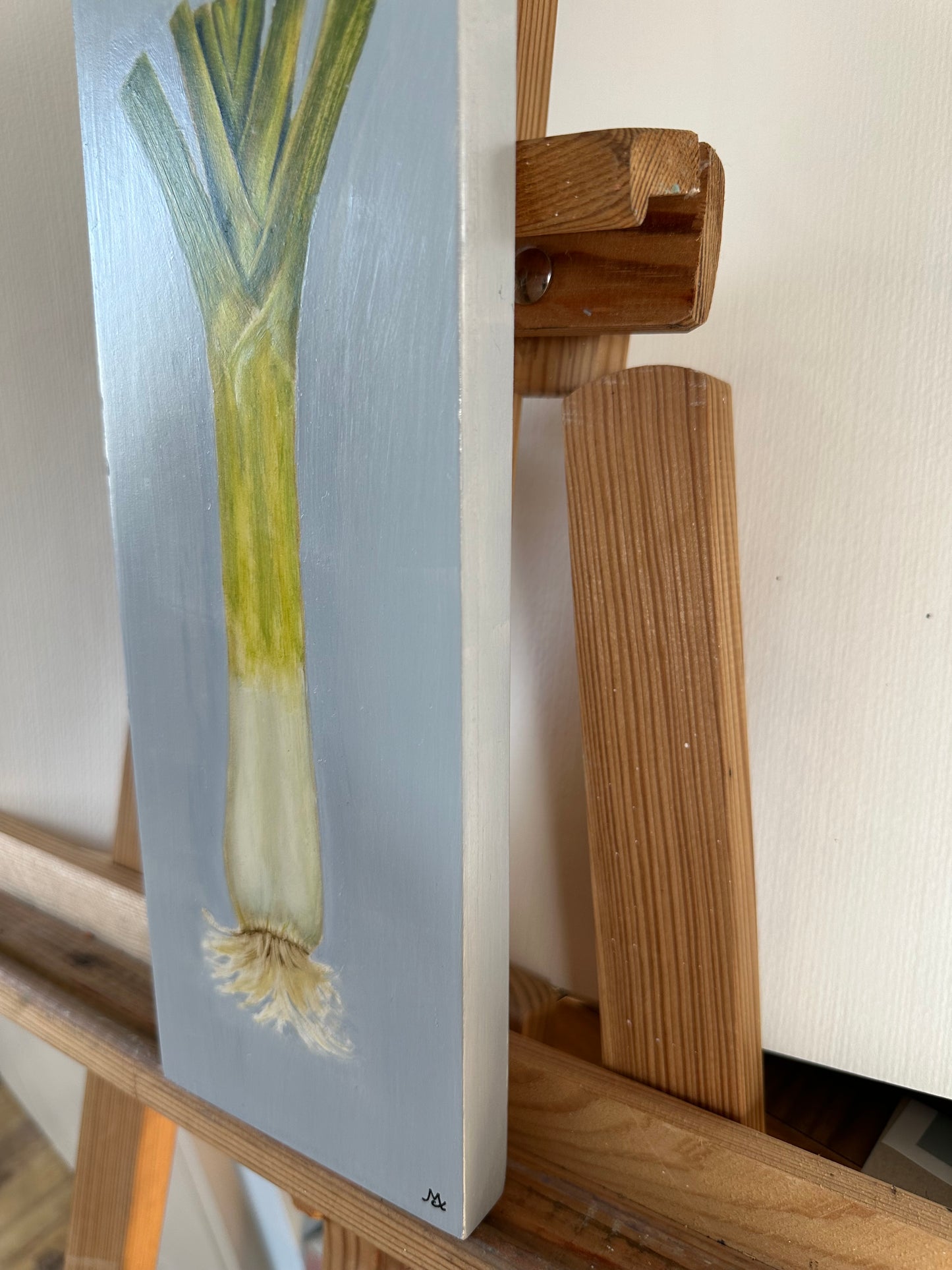 Original oil painting of a leek on a blue background by Cotswold artist Susan McCraith